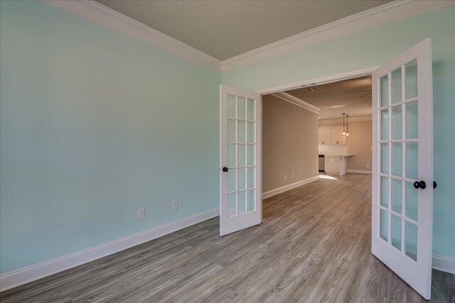 unfurnished room featuring hardwood / wood-style floors, crown molding, and a wealth of natural light