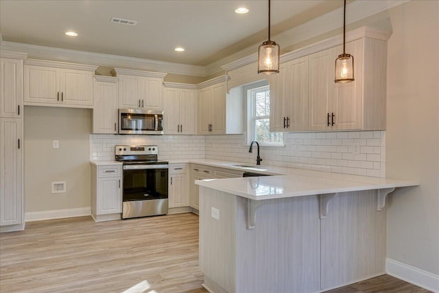 kitchen featuring pendant lighting, a breakfast bar area, stainless steel appliances, and kitchen peninsula