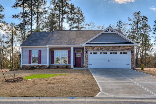 view of front of property with stone siding, driveway, and a garage