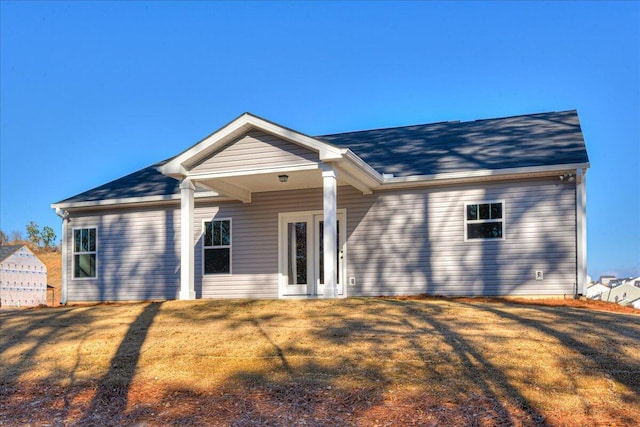 rear view of property featuring a yard