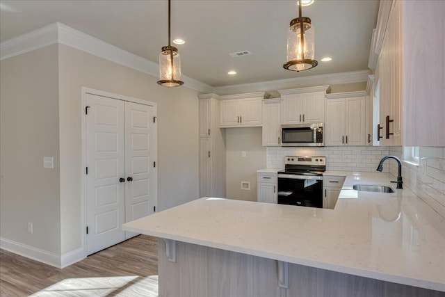 kitchen featuring stainless steel appliances, hanging light fixtures, sink, and backsplash