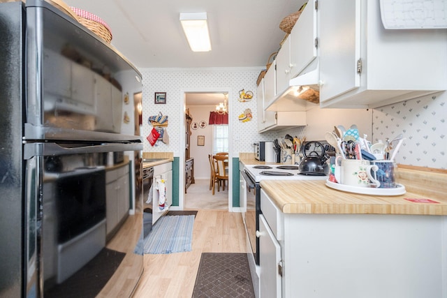 kitchen featuring wallpapered walls, light countertops, under cabinet range hood, light wood-style flooring, and black appliances