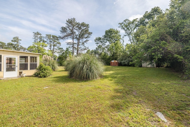 view of yard featuring a storage unit and a sunroom