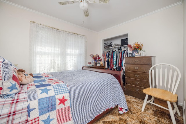 carpeted bedroom with a walk in closet, ceiling fan, crown molding, baseboards, and a closet