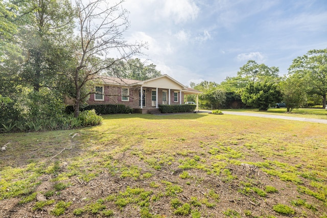 view of front facade with a front yard and brick siding