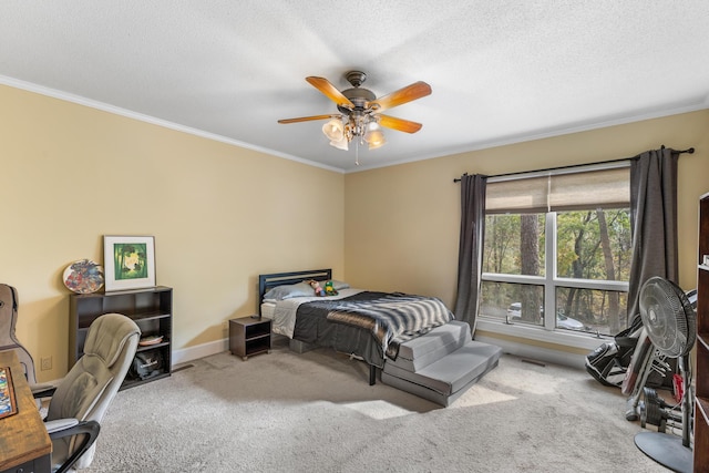 bedroom featuring a textured ceiling, light colored carpet, ceiling fan, and ornamental molding