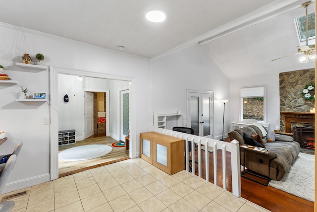 bathroom featuring a fireplace, tile patterned flooring, ceiling fan, and lofted ceiling