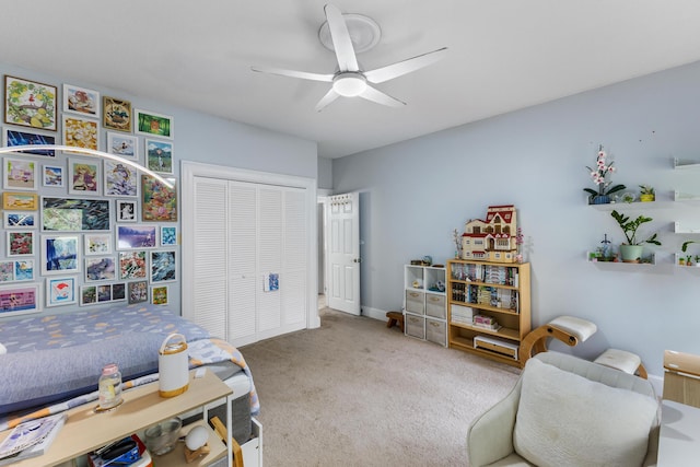 carpeted bedroom with ceiling fan and a closet