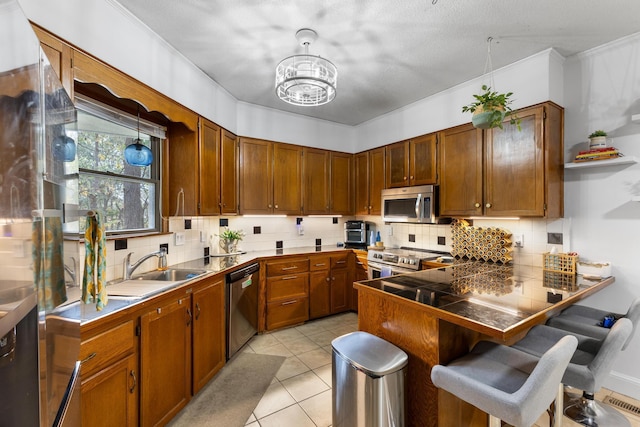 kitchen with a kitchen breakfast bar, sink, decorative backsplash, light tile patterned floors, and stainless steel appliances