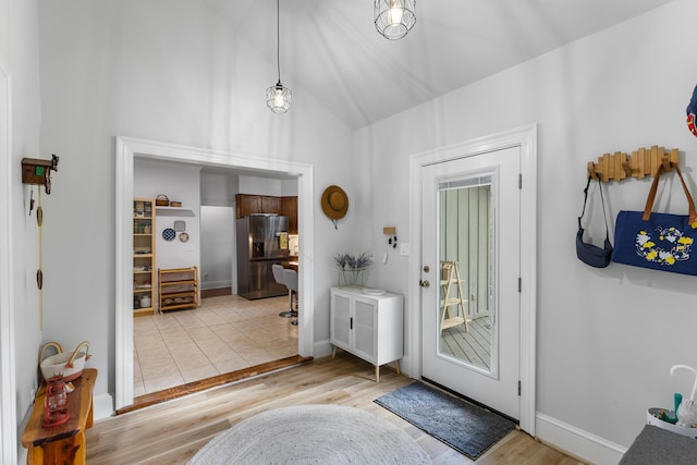 doorway featuring light hardwood / wood-style flooring and vaulted ceiling