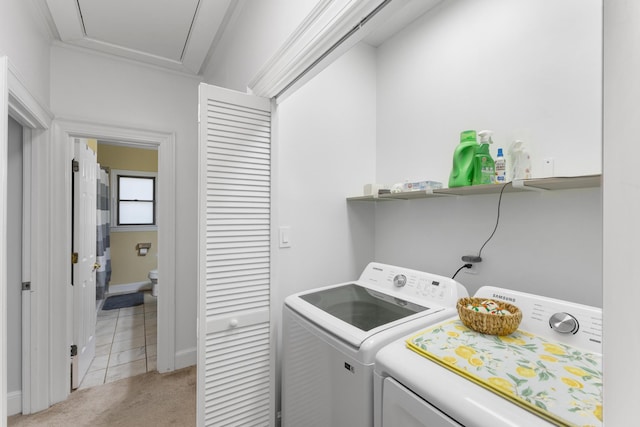 laundry area with crown molding, light colored carpet, and washer and dryer