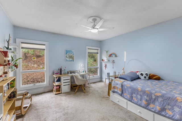 bedroom featuring multiple windows, ceiling fan, and a textured ceiling