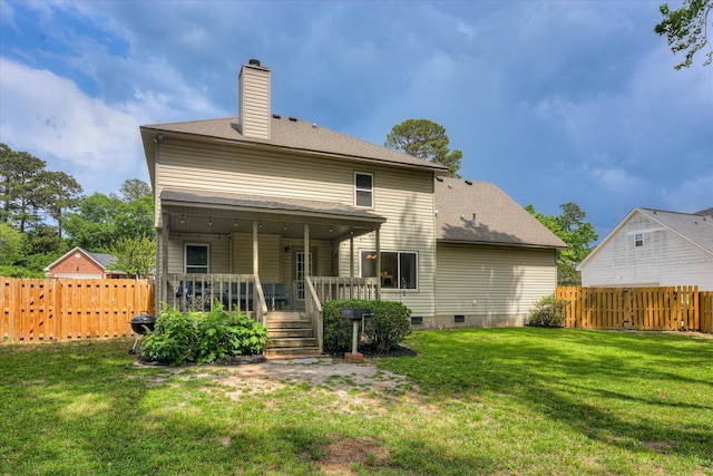 rear view of property with a chimney, a fenced backyard, a yard, and crawl space