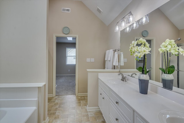 full bathroom featuring visible vents, vaulted ceiling, double vanity, and a sink