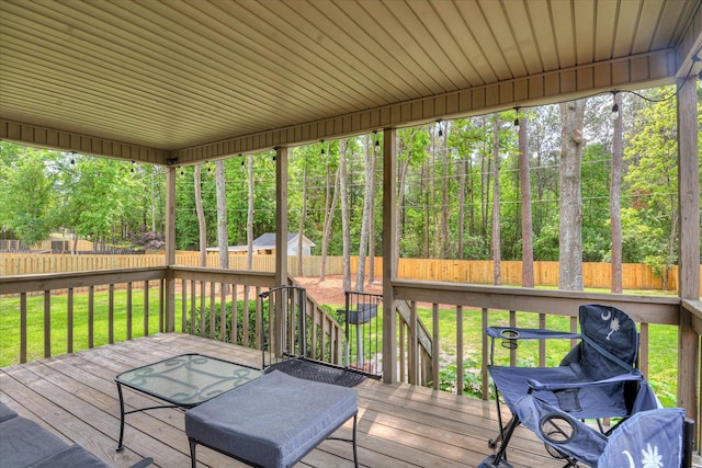 wooden deck featuring a fenced backyard and a lawn