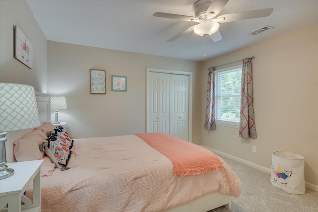 bedroom with a closet, carpet flooring, baseboards, visible vents, and a ceiling fan