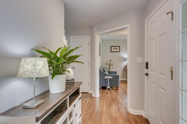 foyer with light wood-style floors and baseboards