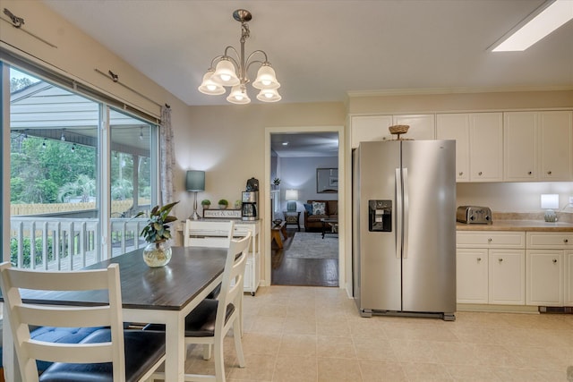dining area featuring a toaster, light tile patterned floors, and a notable chandelier