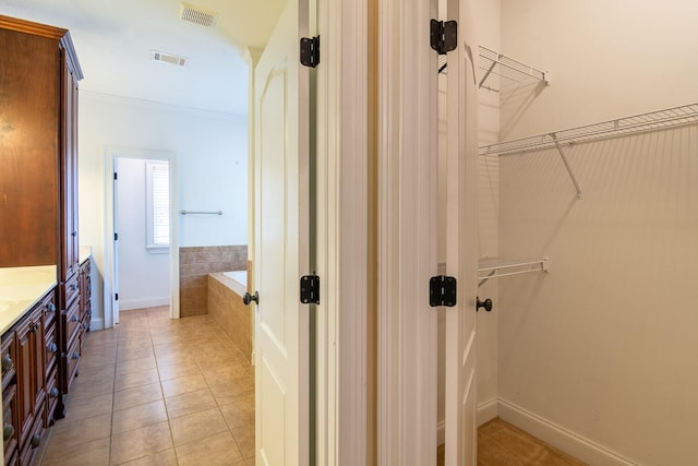 219 Devonshire Dr, Thomson, GA 30824 - bathroom featuring a garden tub, vanity, a walk in closet, and tile patterned flooring