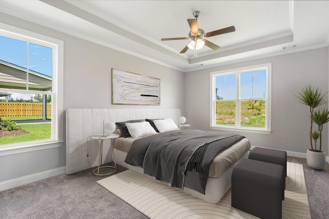 carpeted bedroom with multiple windows, crown molding, and a tray ceiling