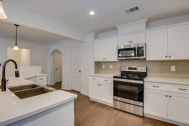 818 Fenwick Ct, Grovetown, GA 30813 - kitchen with appliances with stainless steel finishes, crown molding, arched walkways, a sink, and white cabinets