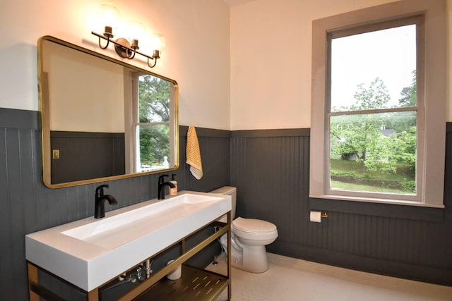 bathroom featuring vanity, toilet, and wainscoting