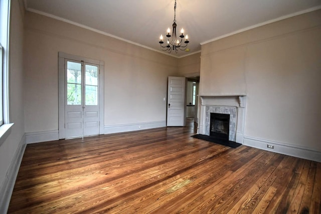 unfurnished living room featuring hardwood / wood-style floors, a chandelier, a tiled fireplace, and crown molding