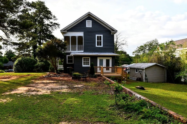 rear view of property with a wooden deck, a lawn, and french doors