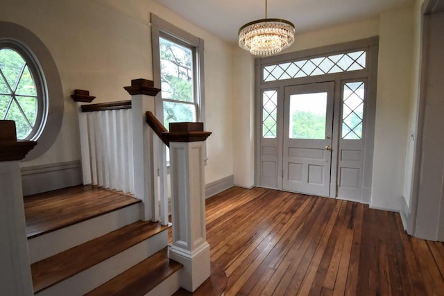 entryway featuring plenty of natural light, an inviting chandelier, and hardwood / wood-style flooring