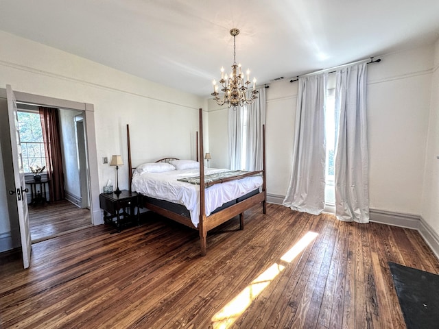 bedroom featuring dark wood finished floors, a notable chandelier, and baseboards