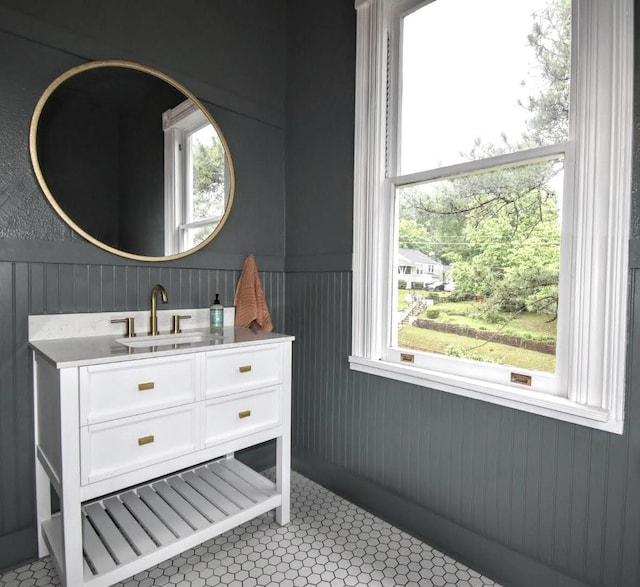 bathroom featuring vanity, plenty of natural light, and wainscoting