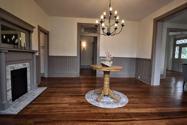 dining area with a notable chandelier, wainscoting, a fireplace, and wood finished floors