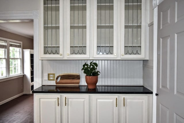 bar with brick floor, crown molding, and baseboards