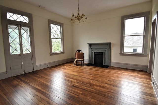 entrance foyer with a chandelier, a fireplace, baseboards, and hardwood / wood-style flooring