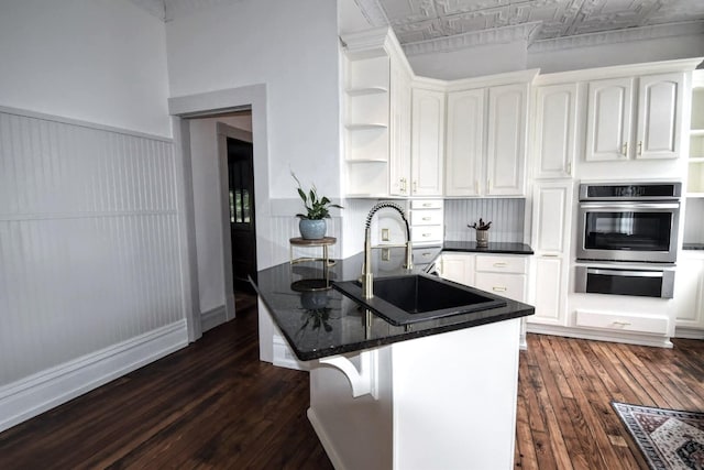 kitchen featuring open shelves, a peninsula, an ornate ceiling, and a sink