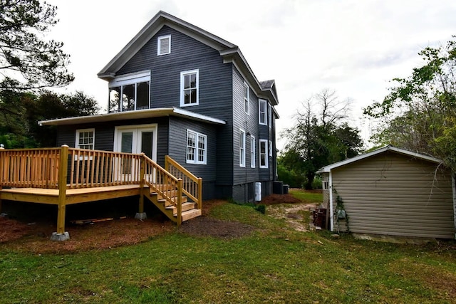 back of house with an outbuilding, central air condition unit, a lawn, and a wooden deck