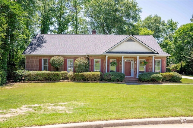4482 Persimmon St, Evans, GA 30809 - view of front of home featuring brick siding, a front yard, a chimney, a shingled roof, and covered porch