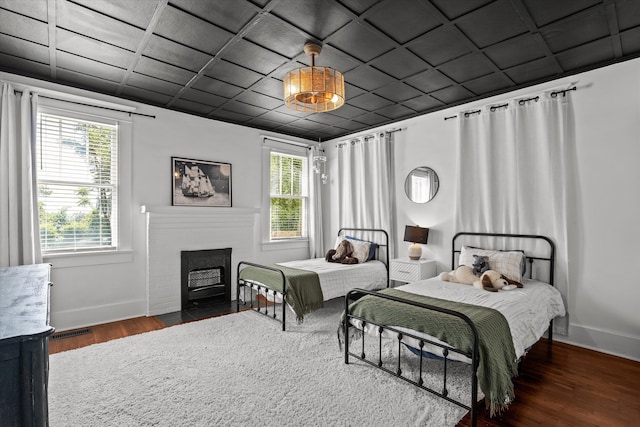 1512 Johns Rd, Augusta, GA 30904 - bedroom featuring baseboards, multiple windows, wood finished floors, and a fireplace with flush hearth