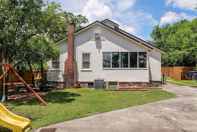 1512 Johns Rd, Augusta, GA 30904 - rear view of house featuring a playground, a chimney, stucco siding, and central AC