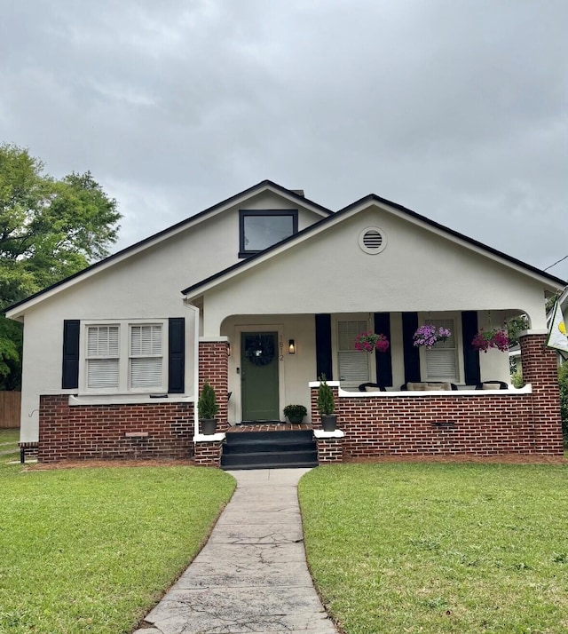1512 Johns Rd, Augusta, GA 30904 - bungalow-style house featuring stucco siding, a front yard, a porch, and brick siding