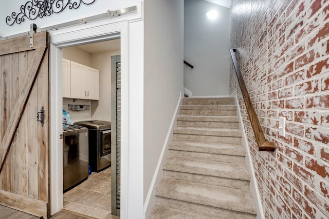 708 Shea Ct, Evans, GA 30809 - staircase with separate washer and dryer, brick wall, a barn door, and baseboards