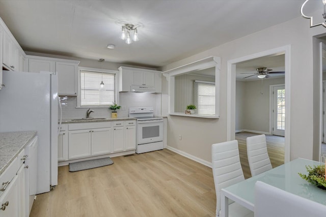 kitchen with light wood finished floors, white cabinets, a sink, white appliances, and under cabinet range hood