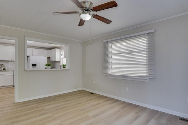 unfurnished living room with baseboards, visible vents, light wood-style flooring, ceiling fan, and crown molding