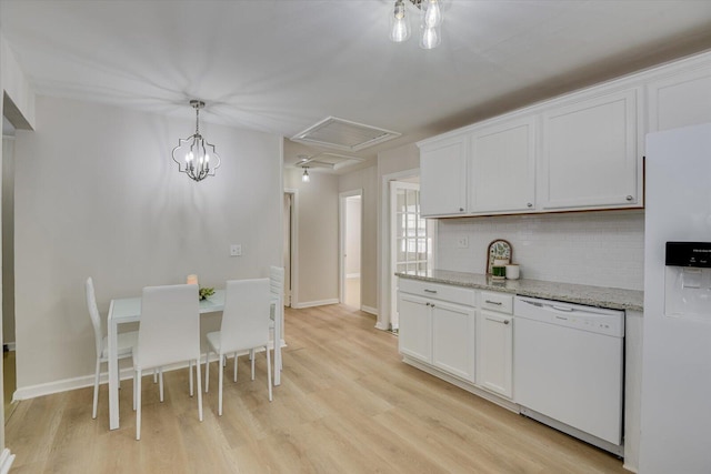 kitchen with white appliances, light wood-style floors, white cabinets, decorative backsplash, and pendant lighting