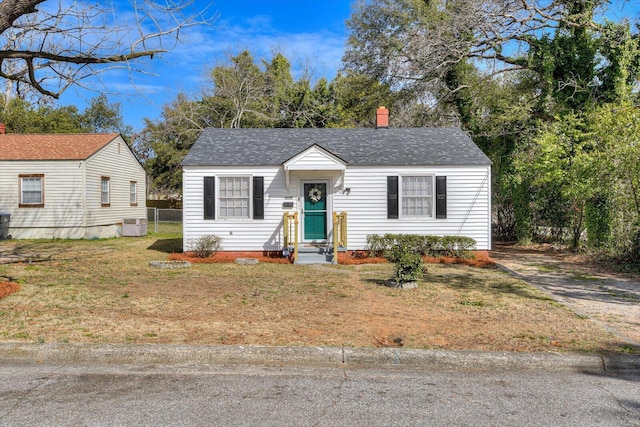 view of front of home featuring a shingled roof and a front lawn