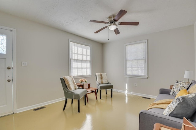 sitting room with baseboards, visible vents, and a textured ceiling