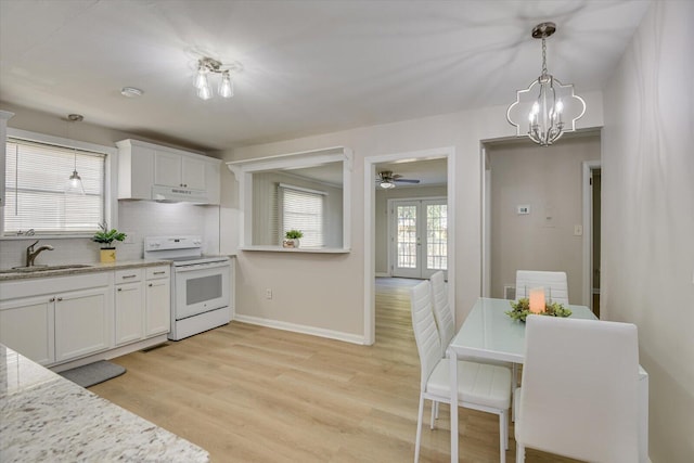 kitchen featuring french doors, hanging light fixtures, electric range, white cabinets, and a sink