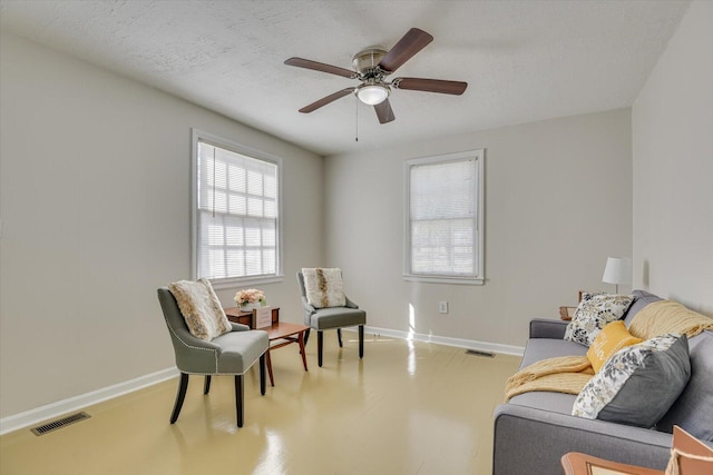 sitting room featuring visible vents, a textured ceiling, and baseboards