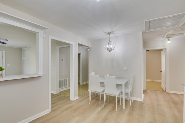 dining space featuring light wood finished floors, baseboards, visible vents, and ceiling fan with notable chandelier