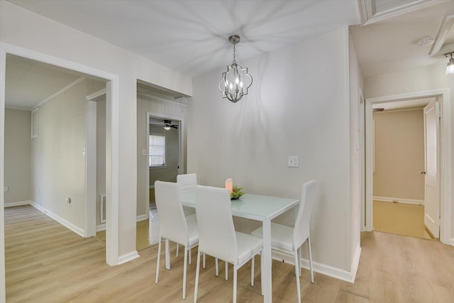 dining space with light wood finished floors, visible vents, baseboards, and an inviting chandelier